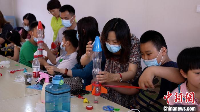 学生们在老师指导下制作水火箭。　王鑫铭 摄